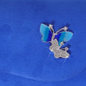 Blue evening clutch detail featuring exquisite rhinestone and enamel butterfly ornament.