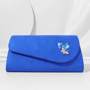 Detailed view of a stunning blue velvet evening clutch bag featuring a sparkling crystal butterfly.