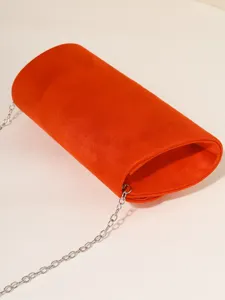 Orange velvet evening bag with silver chain strap, elegant detail for women's crossbody wear.
