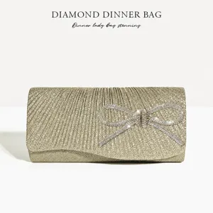 Elegant gold pleated evening clutch bag with sparkling rhinestone bow for party events.