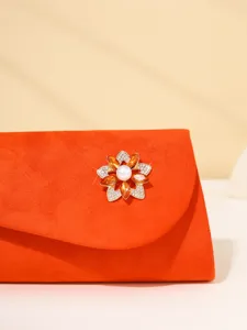 Orange suede evening clutch bag featuring an exquisite crystal flower brooch and pearl detail.
