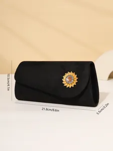 Detailed view of the black velvet evening clutch featuring a sparkling rhinestone sunflower brooch.