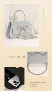 Close up details of silver glitter evening handbag featuring sparkling rhinestone bow and chain.