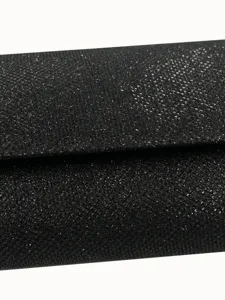 Close-up detail view of black glitter evening bag fabric texture and shimmering finish