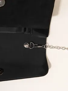 Black evening clutch bag detail shot featuring silver metal chain strap and hardware snap.