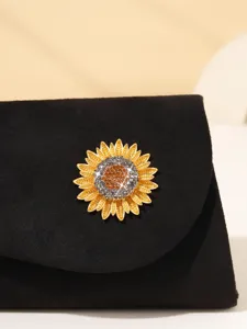 Exquisite sunflower rhinestone brooch displayed on a chic black velvet evening clutch bag.