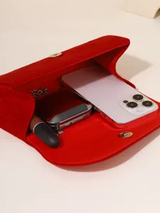 Red velvet evening clutch bag for women, elegant folded design with chain strap and clasp.