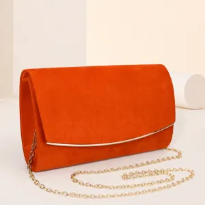 Borsa da sera arancione in camoscio con tracolla a catena metallica, design elegante chic.
