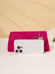 Detailed closeup of pink velvet evening clutch bag with exquisite rhinestone butterfly