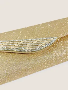Primo piano dettagliato di una pochette da sera dorata glitterata con strass scintillanti.