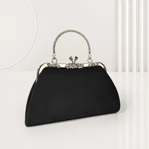 Sac de soirée élégant en velours noir avec poignée en métal brillant et fermoir chic.