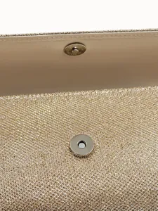 Gold glitter evening clutch bag detail showing magnetic snap closure and sparkly fabric texture.