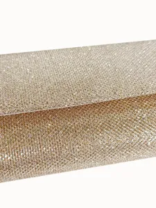 Close-up detail shot of sparkling gold glitter evening clutch bag texture, elegant fabric style.