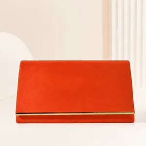 Elegant orange velvet evening clutch bag with metal bar trim for women parties and weddings.