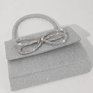 Silver rhinestone evening bag for women, sparkling mini bow handbag with top handle.