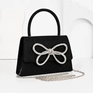 Sparkly black evening handbag with crystal bow, top handle and chain strap for women.