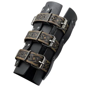 Close-up of medieval leather bracer featuring embossed straps and metal buckles detail.