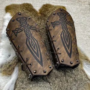 Gros plan de brassards en cuir style viking médiéval avec motifs celtiques et clous.