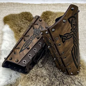 Détail de protège-bras en cuir médiéval avec rivets et motifs gaufrés celtiques pour le cosplay.