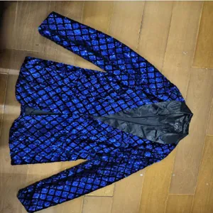 Men blue sequin blazer detail view, peak lapel party suit jacket sparkling diamond pattern.