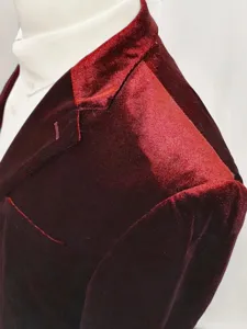Close-up detail shot of men wine red velvet suit jacket shoulder and lapel craftsmanship.