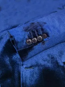 Close-up detail of luxury men's royal blue velvet suit jacket sleeve cuff with four buttons.