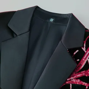 Close-up detail of boys black velvet blazer suit with red sequin branch embroidery lapel.