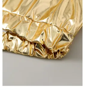 Close-up detail of shiny metallic gold quilted puffer jacket cuff with elastic hem texture.