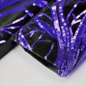 Close-up detail of boys luxury velvet suit featuring sparkling purple sequin branch embroidery.