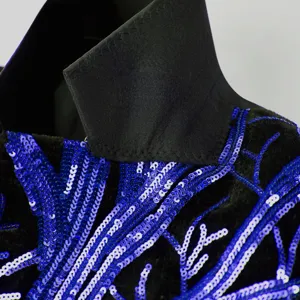 Close-up detail of boys suit collar and blue sequin tree branch embroidery craftsmanship.