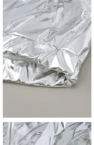 Silver metallic jacket detail close-up showing fabric texture, zipper and elastic cuff.