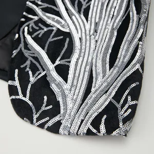 Detailed view of kids suit jacket with silver sequin tree branch embroidery on black fabric.