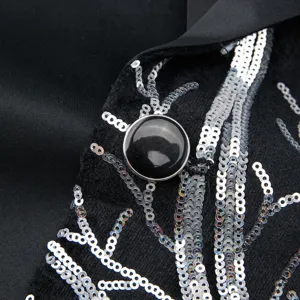 Boys suit jacket detail close-up showcasing shiny silver sequin embroidery and black button.