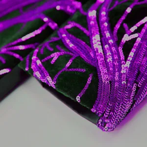 Close-up detail of boys velvet suit featuring vibrant purple sequin branch embroidery.