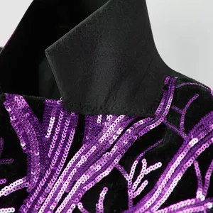 Close-up detail of boys sparkly sequin suit jacket collar and purple branch embroidery.