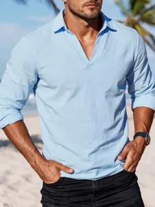 Detail view of a light blue long-sleeve V-neck shirt worn by a model on a sunny beach.