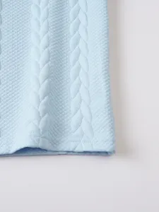 Close-up detail of light blue waffle knit fabric featuring vertical cable texture for summer top