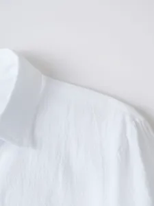 Detail shot of mens solid color lapel long sleeve casual shirt in classic white style.