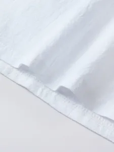 Close-up detail of men's casual solid color long sleeve shirt hem, neat stitching texture.