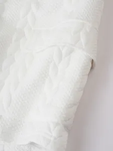 White jacquard fabric texture close-up for men's casual sportswear set detailing knit pattern.