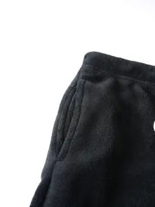 Close-up detail of mens black fleece casual pants pocket and waistband, soft plush texture.