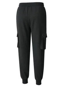 Close-up detail of black waffle knit cargo sweatpants, featuring side pockets and cuffs.