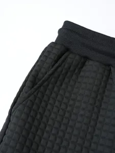 Close-up detail of black waffle knit men's casual pants waist and pocket texture.