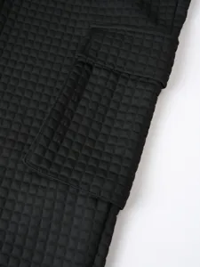 Black waffle cargo pants fabric detail, casual sports trousers texture close up view.