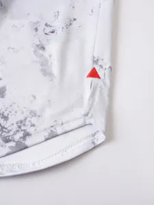 Detailed view of men's athletic shirt hem with marble print and red triangle embroidery.