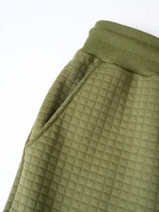 Olive green waffle knit casual pants pocket and waistband detail close-up photo.
