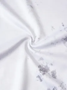 Close-up view of white and grey tie-dye breathable mesh fabric with natural folds.