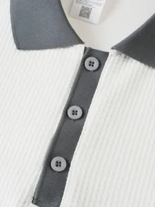 Close-up view of white and grey waffle knit polo shirt collar and buttons detail.