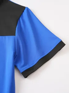 Primo piano dettagliato del top a maniche corte bicolore con un pannello blu e nero.