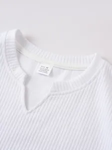 White ribbed V-neck tank top fabric detail view showing texture and inside size label.